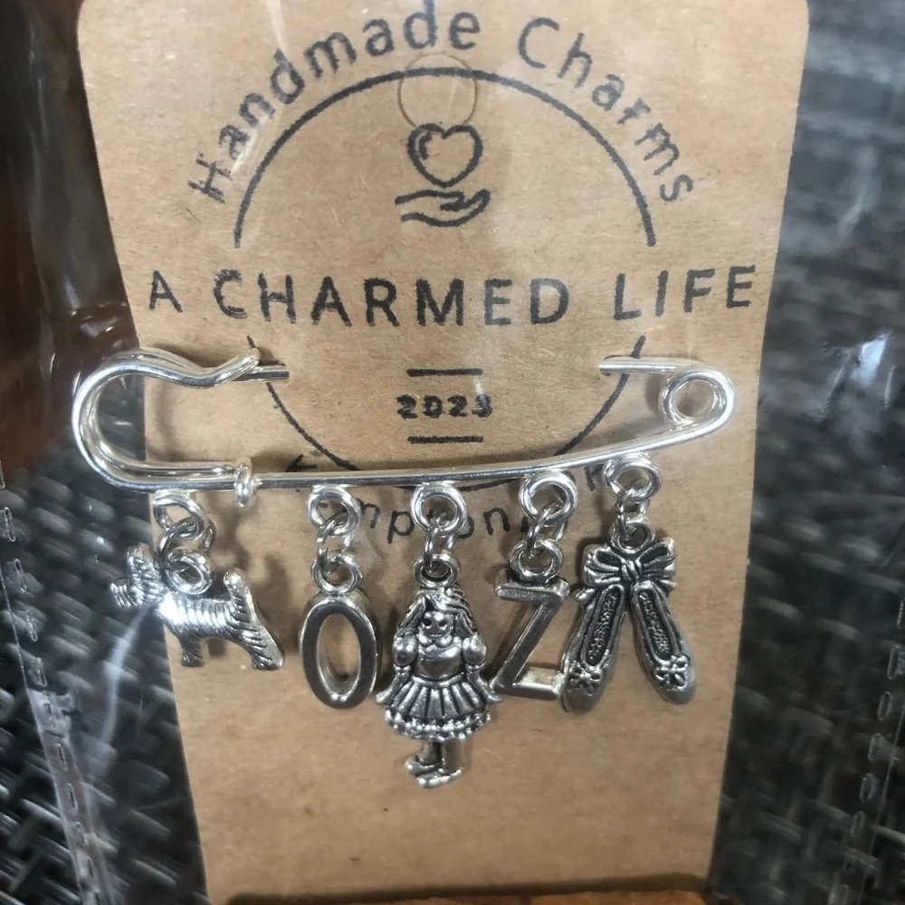 NWT, Handmade by A Charmed Life. Wizard of Oz Silver Charms/Silver 2” Pin